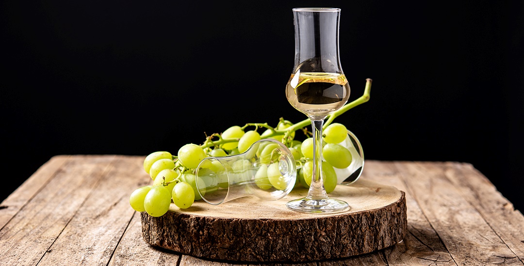 Grappa gefülltes Glas und Trauben