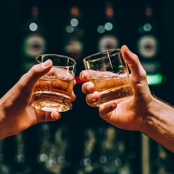 Zwei Personen, die mit Cognac anstoßen.