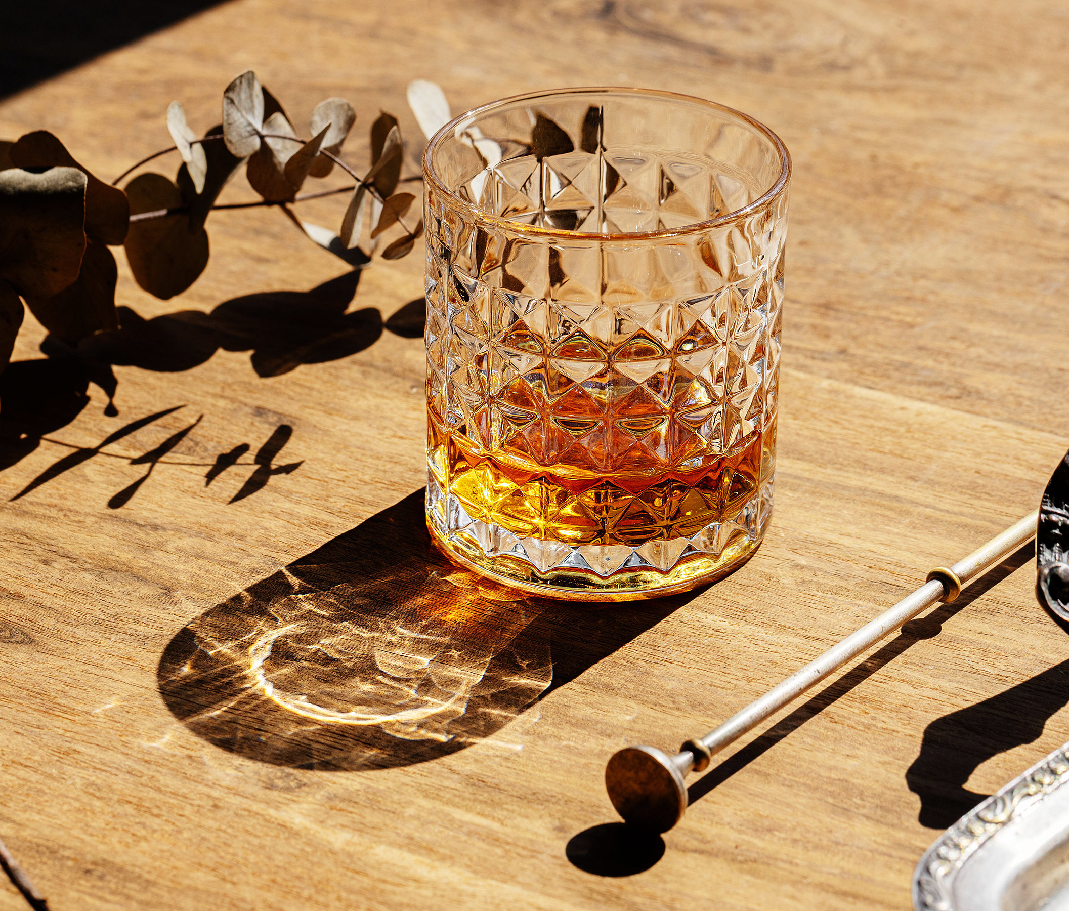 Ein Glas gefüllt mit Cognac auf einem Eichenholztisch.