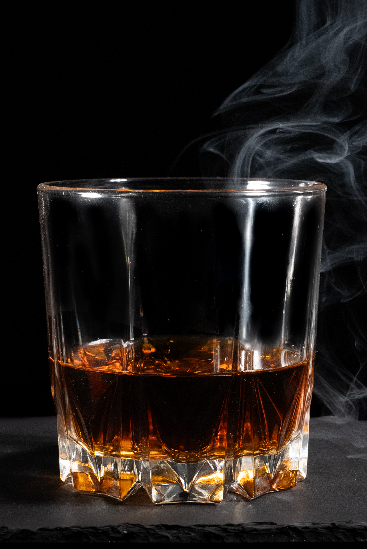 Ein gefülltes Glas mit Cognac und dezentem Rauch.